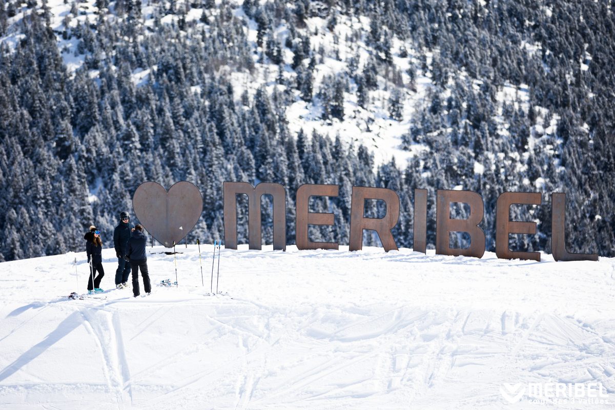 Love Meribel sign in snow with trees in background