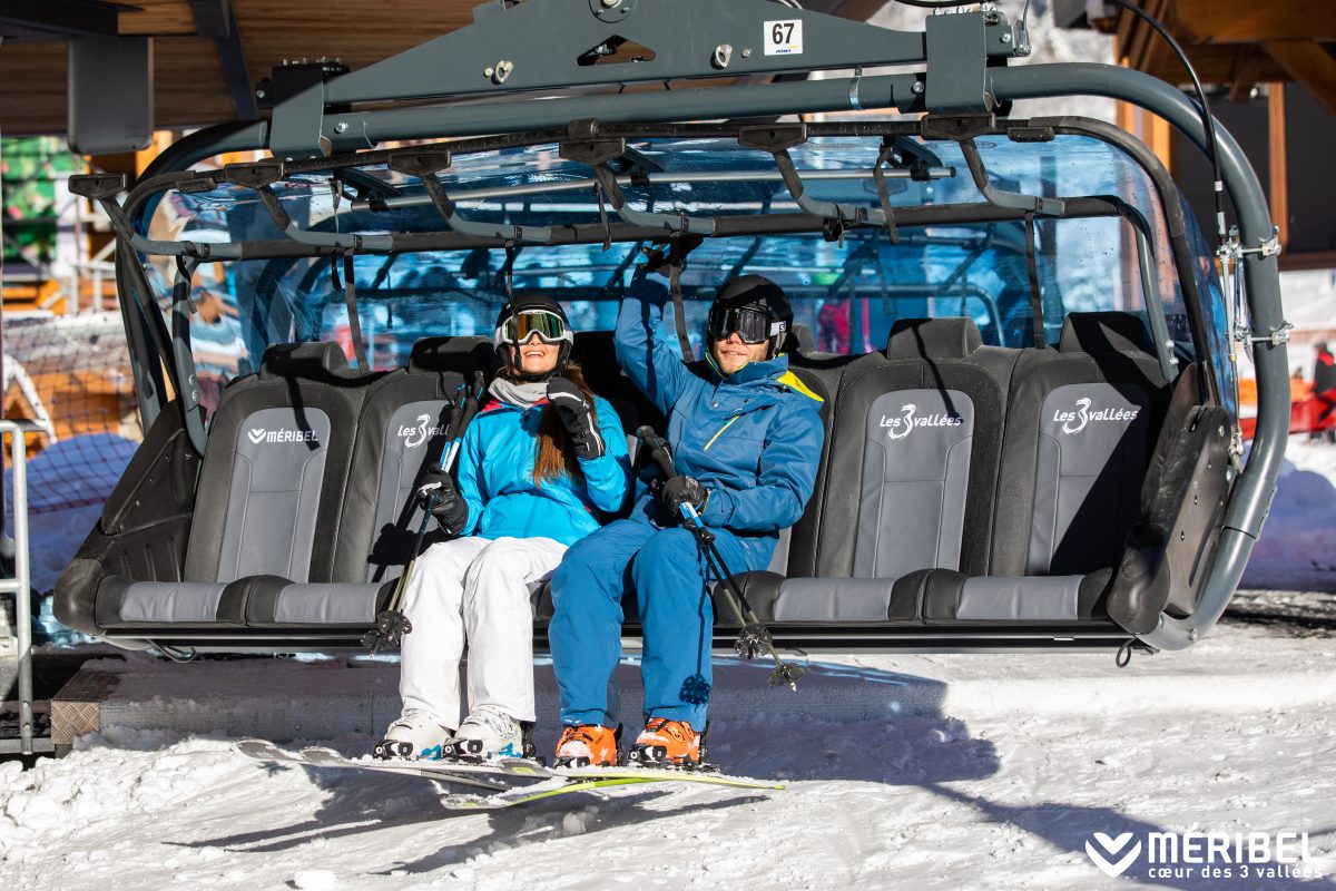 two skiers using their meribel lift pass on the legends chairlift at the Chaudanne 