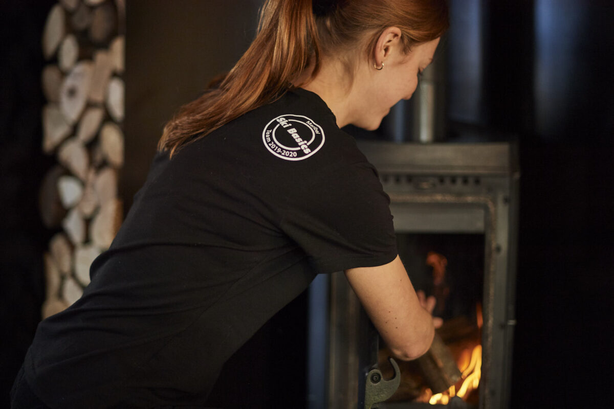 Ski basics. chalet host preparing a fire in the log burner in catered ski chalet Chalet Victoire in Meribel Village