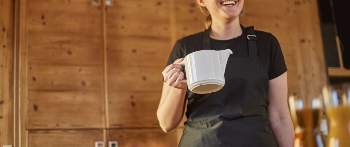 chalet host preparing pot of tea for guests in catered ski chalet