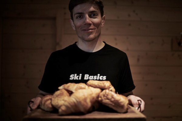 James Jacob in Ski Basics t-shirt, holding croissants