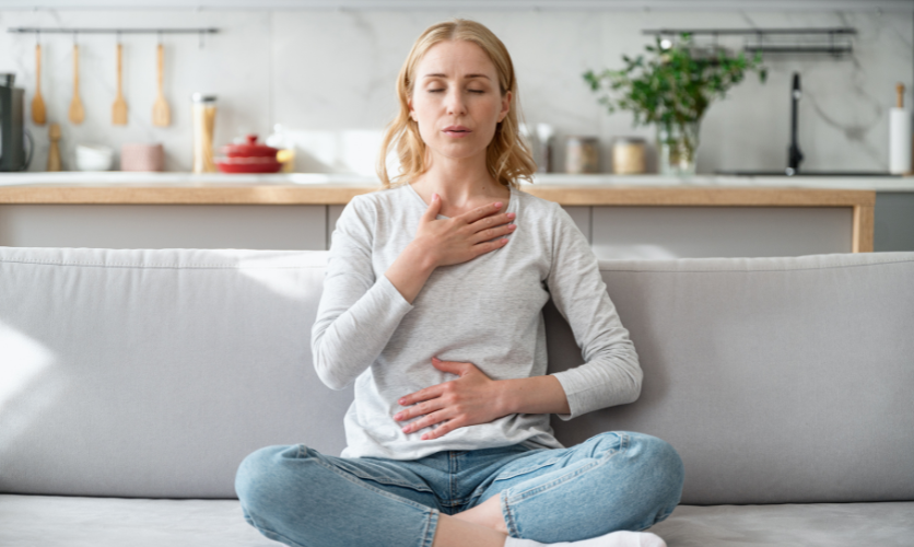 Female sat on sofa practicing breathing Exercises to Improve Oxygen Efficiency at high altitude 